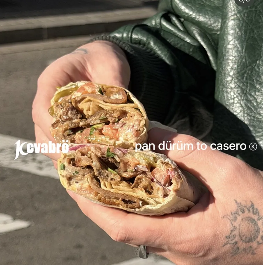 Dürüm cortado por la mitad sujeto con la mano